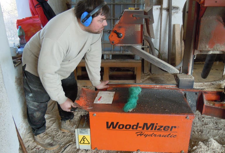 The sawmill operator manipulates log with hydraulics